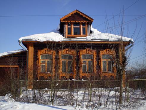 В центре поселка деревенский дом с дивными резными наличниками. 